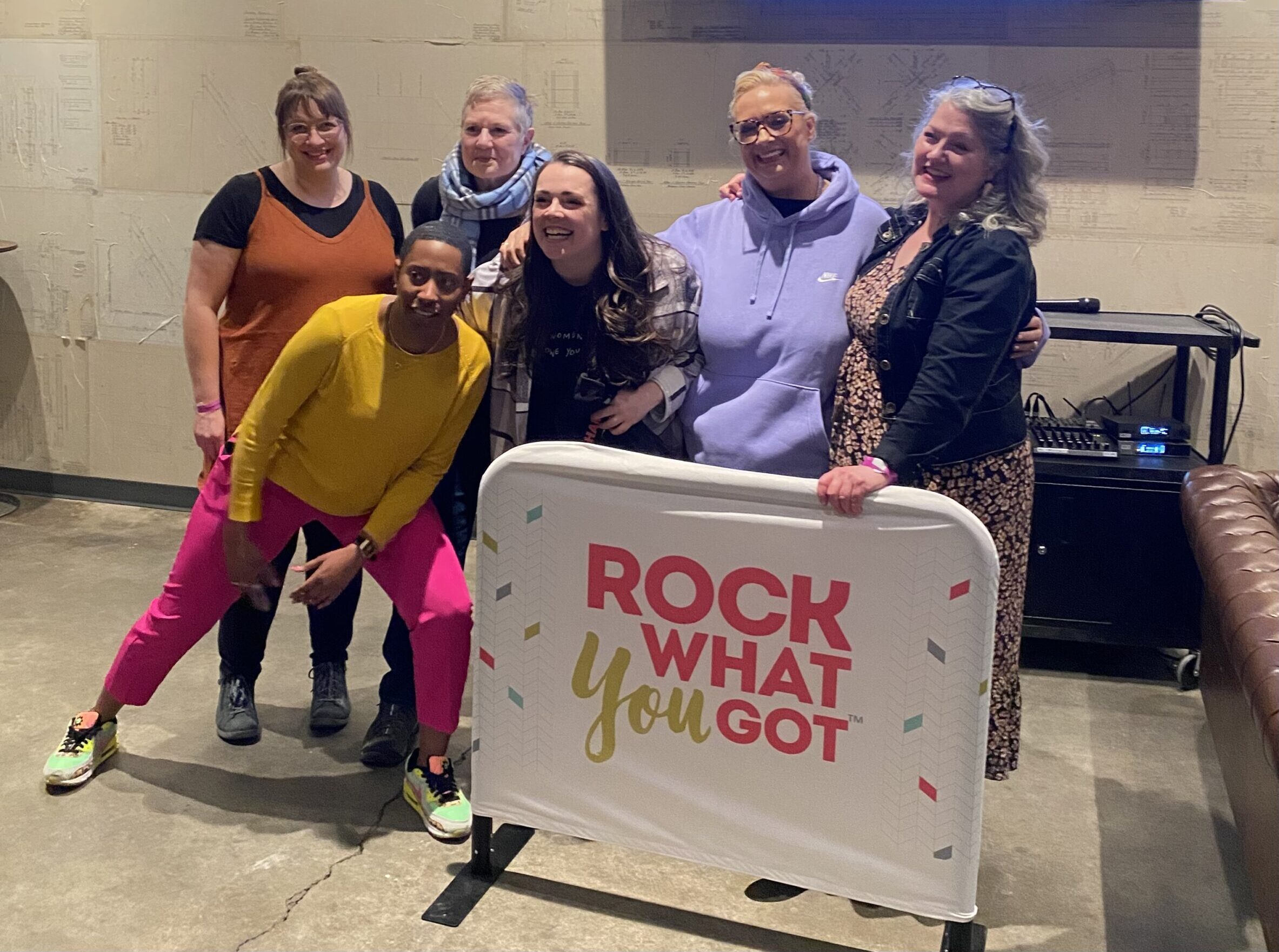 ComedianswithInvenuewithStageMonitor Comedians and RWYG facilitators standing behind Rock What You Got signage.